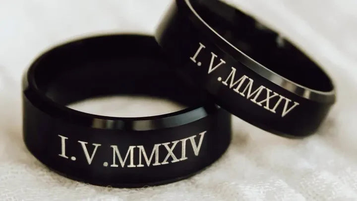 Pair of black matching couple rings with engraved date